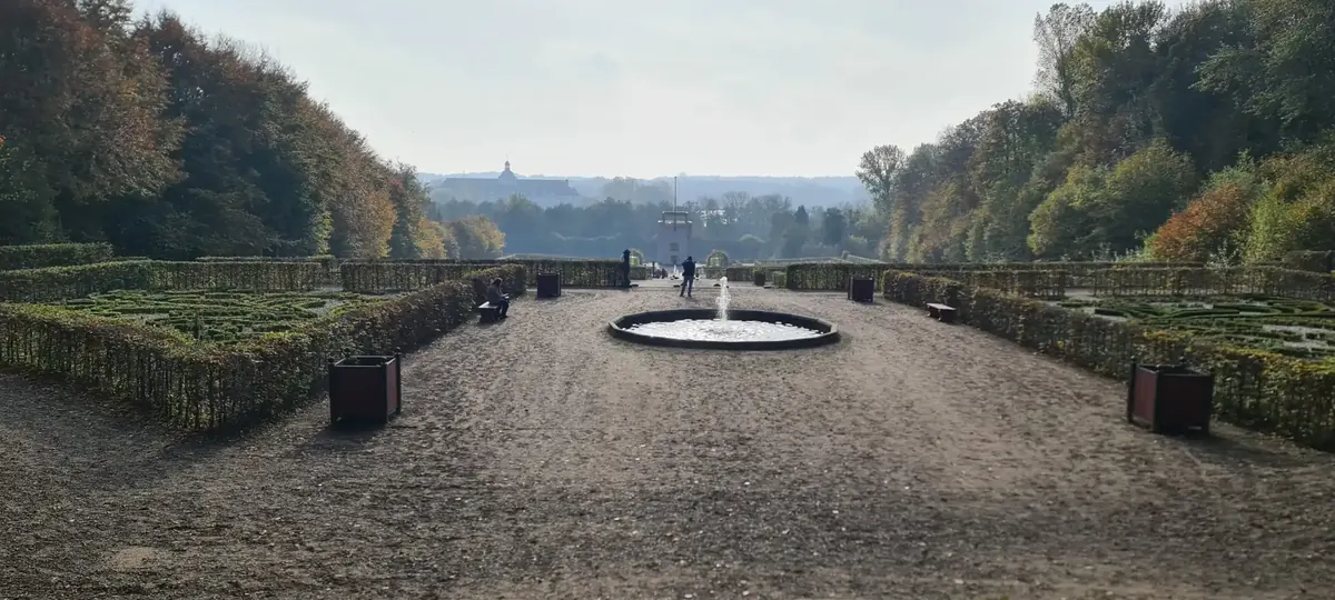 Der Neuwerkgarten von Schloss Gottorf mit geschnittenen Hecken und rundem Wasserbecken.